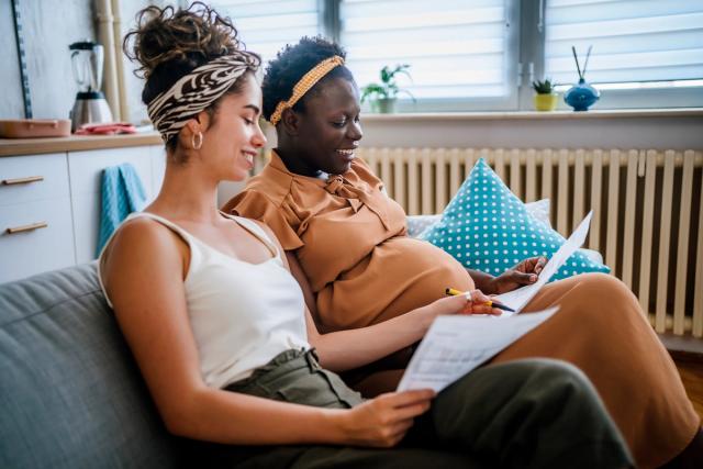Young cheerful pregnant couple planning home renovation and managing budget.