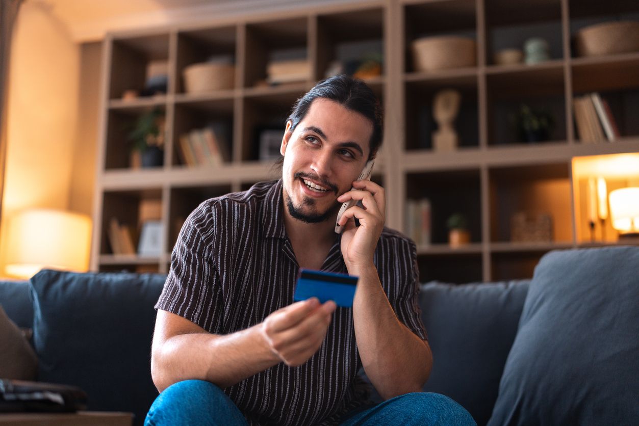 Man on the phone at home calling about activating his credit card.