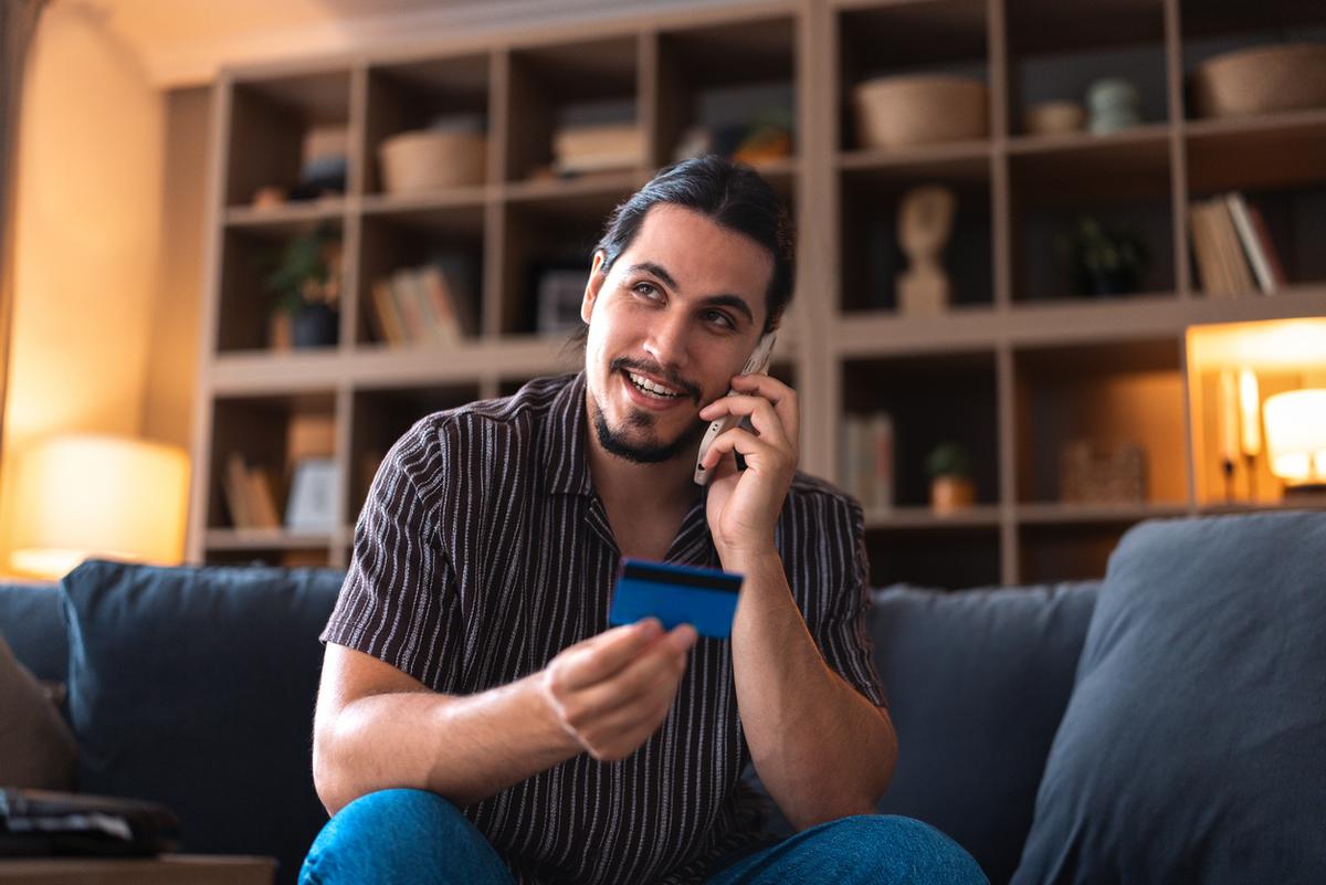 Man on the phone at home calling about activating his credit card.