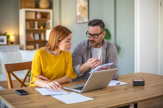 Couple discussing debt repayment methods at home.