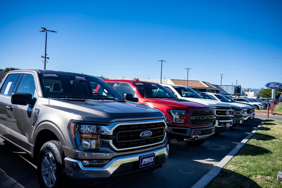 Parked pickup trucks for lease at a car dealership.