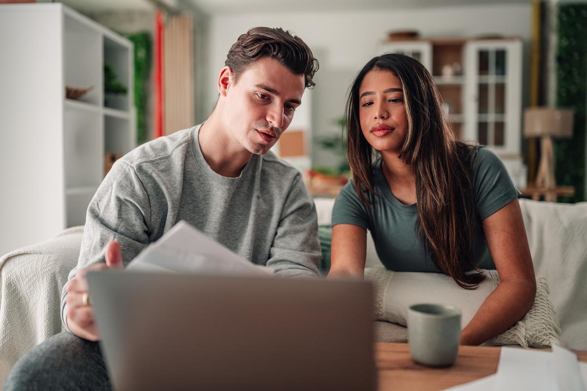 Couple reviewing and comparing a HELOC and home equity loan on a laptop.