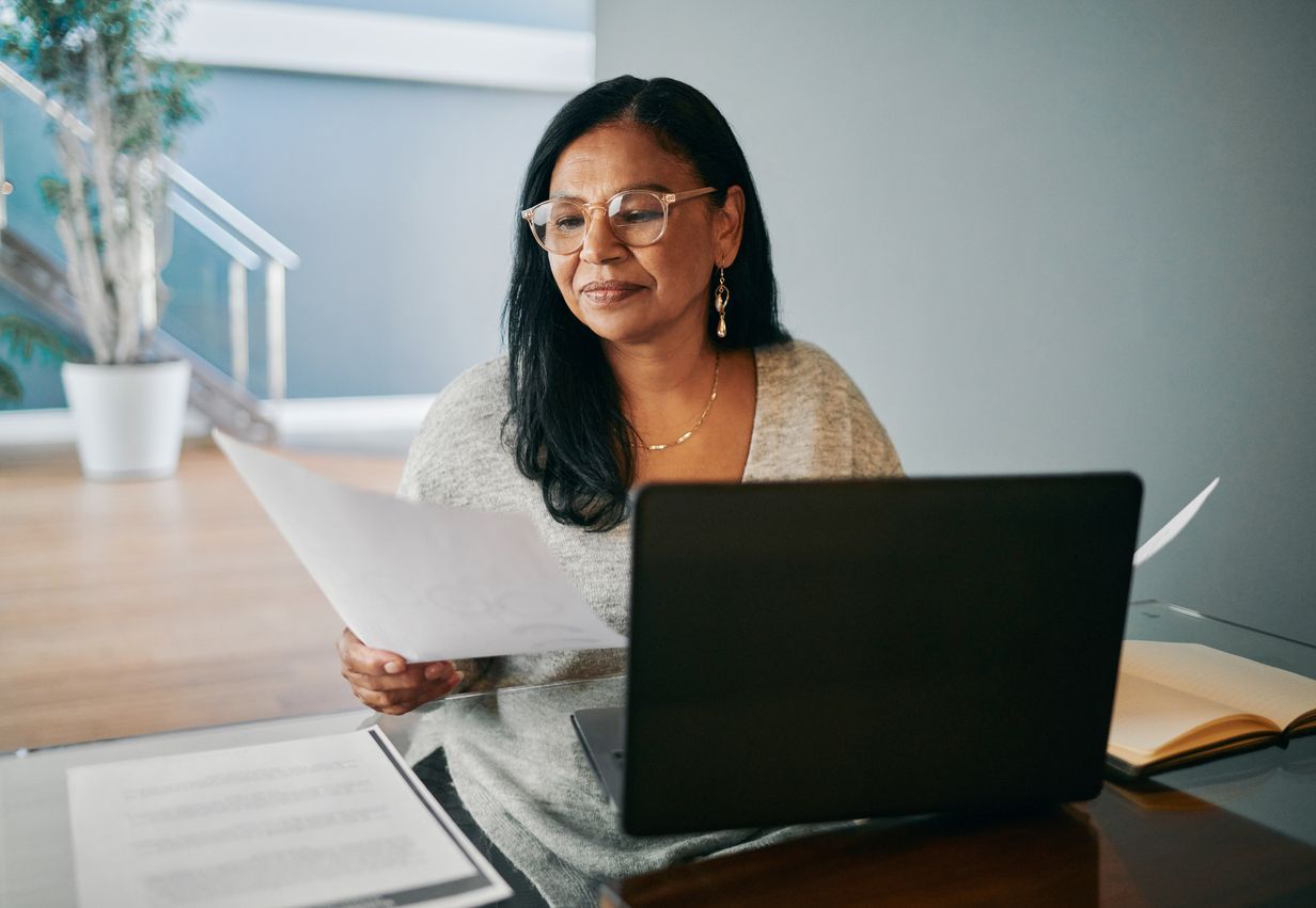 Woman is reviewing a personal loan and a balance transfer credit card at the desk..