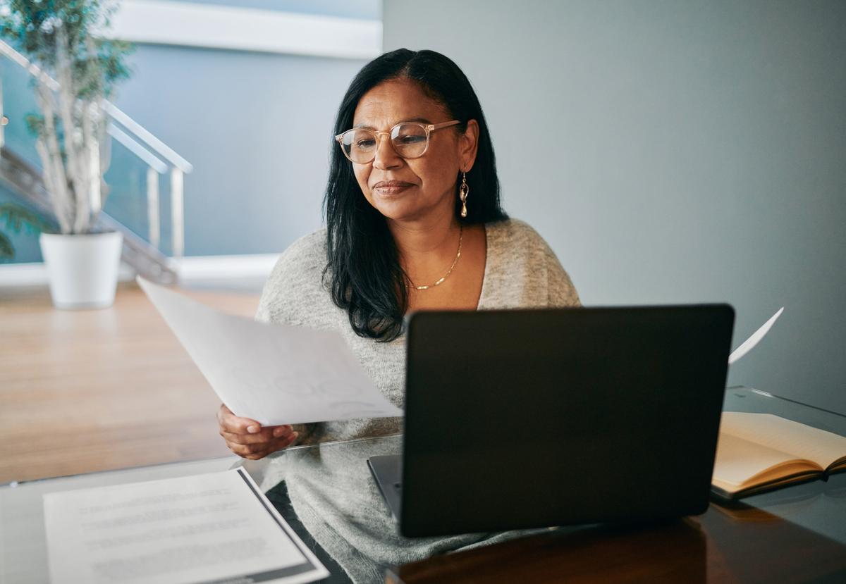 Woman is reviewing a personal loan and a balance transfer credit card at the desk..