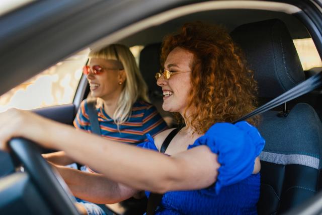 Couple traveling by car in summer, enjoying road trip experience together.