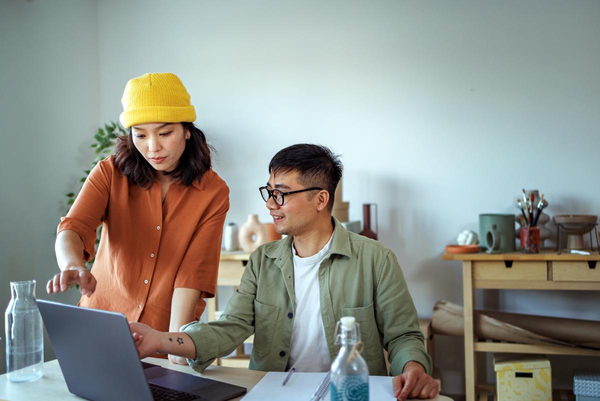Young couple going over finances at home together on laptop.